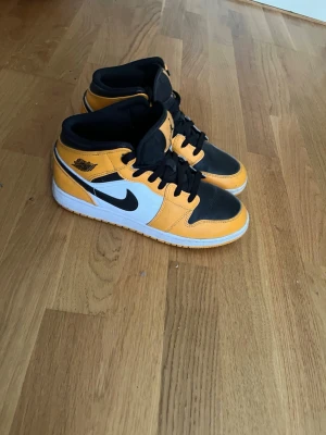 Air Jordan 1 Mid svart/gul/vit - Säljer ett par Air Jordan 1 Mid sneakers i svart, gul och vit. Äkta! Knappt användna. Det går att diskutera priset!
