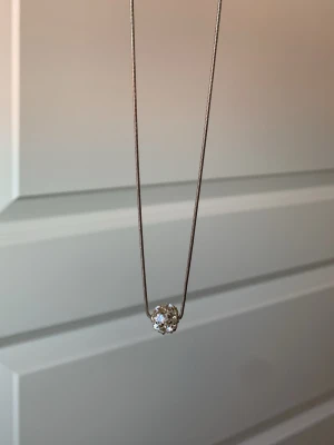 Silverhalsband med glittrande pärla - Snyggt halsband i silverfärg med en rund, glittrande pärla som hänge. Kedjan är tunn och smidig, och pärlan är täckt av små gnistrande stenar som fångar ljuset. Perfekt accessoar för dig som gillar stilrena men ändå iögonfallande detaljer.