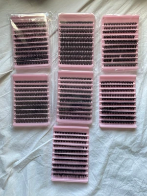 Ögonfranskluster 80D i mixade längder - Säljer flera förpackningar med ögonfranskluster 80D i mixade längder. Fransarna är svarta och sitter på rosa brickor, perfekta för att skapa fylliga och definierade fransar. Varje bricka innehåller flera rader med individuella franskluster för enkel applicering.