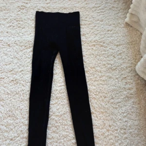 Svarta höga leggings - Säljer ett par svarta leggings med hög midja. De är tighta och stretchiga, perfekta för en clean och enkel look. Passar till det mesta och är riktigt bekväma. Materialet känns mjukt och följsamt.