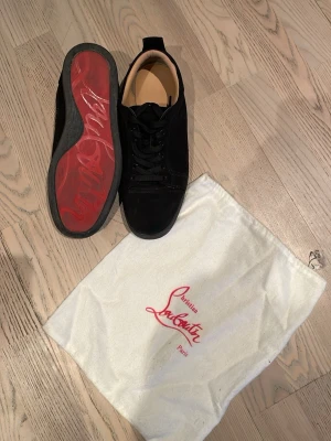 Christian Louboutin skor - Snygga svarta skor i mocka från Christian Louboutin äkta med klassisk röd sula och svarta skosnören. Låg modell med diskret design och beige innerfoder. Kommer med original dustbag med logga. Står även cristian loubotin under skon och inne i sulan där de även stor paris också. Men som syns dåligt på bild som bara blir suddiga. Hör av er om ni vill ha fler bilder