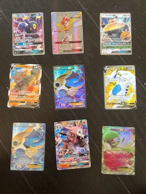 Samling Pokémon GX/EX/V kort - Säljer en samling med 9 Pokémonkort av typen GX, EX och V. Korten är holografiska och har färgstarka motiv med olika Pokémon som Umbreon, Kartana, Snorlax, Arcanine, Blastoise, Lugia, Lycanroc, Mew och Gardevoir. Perfekt för samlare eller Pokémonfans! Vet dock inte 100% om de är äkta. Det går att sänka priset.