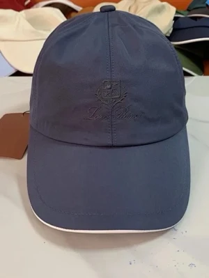 Mörkblå keps från Loro Piana - Snygg mörkblå keps från Loro Piana med broderad logga framtill och böjd skärm. Kepsen har en klassisk sexpanelsdesign och vit kant längs skärmen. Perfekt accessoar för en stilren look.
