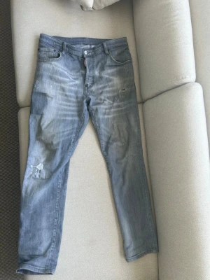 Dsquerd 2 jeans - Säljer ett par gråa  dsquerd 2 jeans som har en bra design med slitningar och sitter väldigt bra inte använd så jätte mycket men de har varit använda då och då.