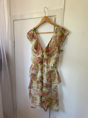 Blommig sommarklänning - blommig sommarklänning med volanger vid kjolen och öppen rygg💓💓 Är i strl 32 men jag som brukar ha 36/38 kan ha denna💕