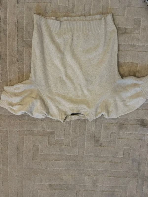 Beige stickad tröja från Vero Moda - Mysig beige stickad tröja från Vero Moda med rund halsringning och ribbade muddar. Tröjan har en enkel och klassisk design som passar perfekt till jeans eller kjol. Materialet känns mjukt och bekvämt mot huden.