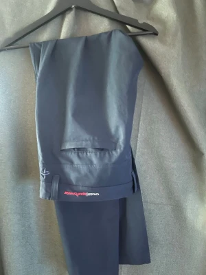 Golfbyxor Cross Sportswear - Snygga mörkblå chinos från Cross Sportswear med rak passform och diskreta bakfickor. Byxorna har en stilren look och är tillverkade i ett mjukt, lätt material som ger en bekväm känsla. Perfekta för dig som gillar en clean och sportig stil.