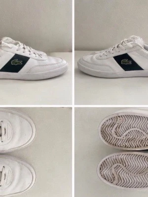 Vita Lacoste sneakers med grönt märke - Säljer ett par vita sneakers från Lacoste med klassisk grön krokodil på sidan och mörkblå detalj. Skorna har lågt skaft, vita snören och sula med fiskbensmönster. Perfekta för dig som gillar stilrena och sportiga skor.