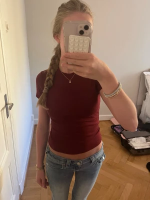 Mörkröd tight t-shirt - Snygg mörkröd t-shirt med tight passform och korta ärmar. Enkel och stilren design som passar perfekt till jeans eller kjol. T-shirten är i mjukt bomullsmaterial och har en klassisk rund halsringning.