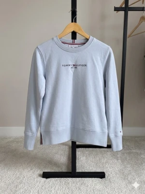 Tommy Hilfiger tröja - Fin tommy tröja i ljusblå, använd en gång så i väldigt bra skick, i princip ny. Den är xss men passar även xs/s  Djur/rökfri hem