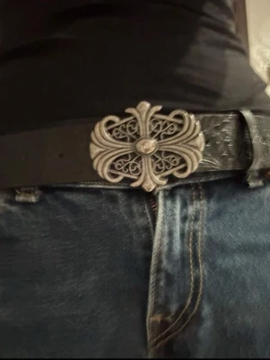 Coolt svart bälte med stor silverdetalj - Snyggt svart bälte med en stor, dekorativt utformad silverspänne i vintage-stil. I väldigt bra skick! 112 Cm långt 