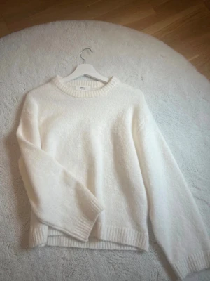 Vit stickad tröja från Gina Tricot💘 - Mysig vit stickad tröja från Gina Tricot i ullblandning. Tröjan har rund halsringning, ribbade muddar och en avslappnad passform. Perfekt för lager på lager och enkel att styla till olika outfits.köpt för 399kr