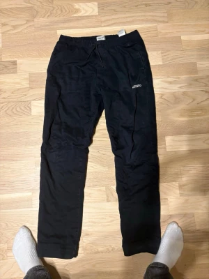 Svarta mjukisbyxor från kenzo - Svarta mjukisbyxor från kenzo med elastisk midja och dragsko. Byxorna har en ficka bak med en stor vit K-detalj och en diskret logga framtill. Sköna och avslappnade med rak passform, perfekta för chill dagar. Materialet känns mjukt och bekvämt.