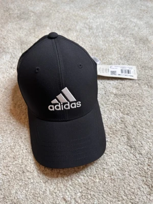 Svart Adidas keps  - säljer en svart adidas keps som passar alla huvudformer, skriv vid intresse!!
