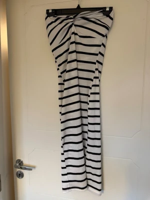 Randig vit klänning - Bandeau klänning med en ”knut” framtill som ger en fin look vid brösten. Aldrig använd men blivit litee smutsig i garderoben, ska självklart tvättas.
