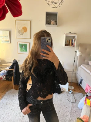Svart Zara spetsblus med volangdetaljer!💝💘 - Säljer den slutsålda svarta, transparenta spetsblusen med långa ärmar och volanger. Super snygg och unik, för dig som vill ha något extra till din outfit!!💖💥