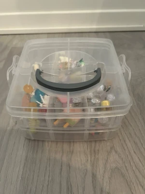 Färgglada örhängen i mixad design - Säljer ett set med flera par örhängen i olika färger och former, bland annat avokado, glassar, pärlor, nallar och regnbågar. Materialen varierar mellan plast, metall och akryl. Perfekt för dig som gillar unika och lekfulla accessoarer. MAN FÅR MED BOXEN OCH GREJERNA INUTI!