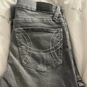 Ljusgrå bootcut jeans från Gina  - Säljer ett par ljusgrå jeans från Gina med bootcut passform och snygga vita kontrastsömmar på bakfickorna. Använda fåtal gånger🤍