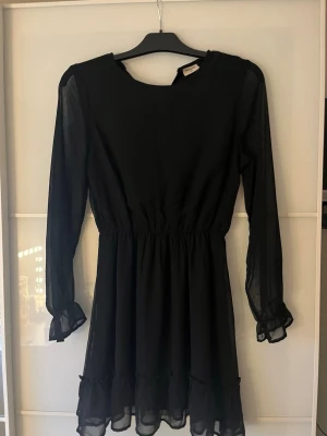 Svart klänning med volanger - Svart klänning med volanger passar till alla möjliga saker är från Kappahl och ärm endast använd nån enstaka gång