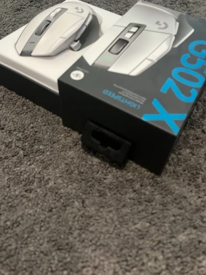Logitech G502 X Lightspeed gamingmus - Säljer en Logitech G502 X Lightspeed gamingmus i vit färg. Musen har flera programmerbara knappar, trådlös anslutning. Perfekt för gaming och produktivitet. Snygg och modern design med tydliga linjer och logotyp.