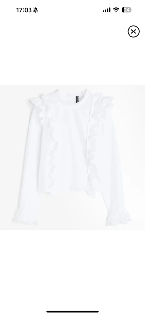Vit blus med volangdetaljer - Superfin vit blus från H&M med långa ärmar och volangdetaljer längs axlar och framtill. Blusen har rund hals och spets vid ärmslut och axlar för en extra söt touch. Perfekt för dig som gillar romantisk och feminin stil. Knappt använd