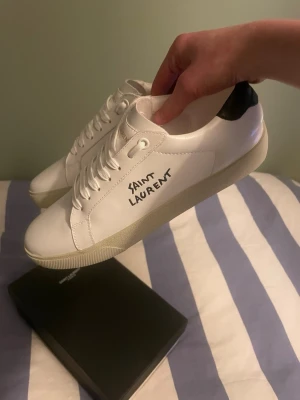 Saint Laurent vita sneakers - Säljer ett par feta Saint Laurent sneakers som är schyssta till våren och sommaren. Allt og medföljer✅ I nyskick✅ Mvh Sixten
