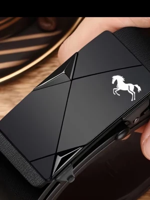 Svart bälte med hästdetalj - Snyggt svart bälte med glansig, geometrisk spänne och en vit hästdetalj på framsidan. Bältet har en modern och stilren look som passar till många outfits. Spännet har en unik design med skarpa linjer och en exklusiv känsla.