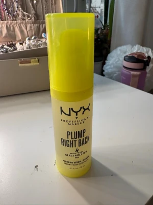 oanvänd NYX Plump Right Back Primer - NYX Plump Right Back Primer är en primer med serumkänsla som kommer i en genomskinlig plastflaska med neon-gult lock och pump. Innehåller elektrolyter för att ge huden en fräsch och återfuktad känsla. Perfekt som bas innan foundation.