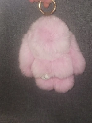 Rosa fluffig kanin nyckelringsaccessoar - Nyckelringsaccessoar i form av en kanin, tillverkad i supermjuk rosa fuskpäls med vita tassar och guldfärgad metallring. Perfekt att hänga på väskan eller använda som dekoration till nycklar.