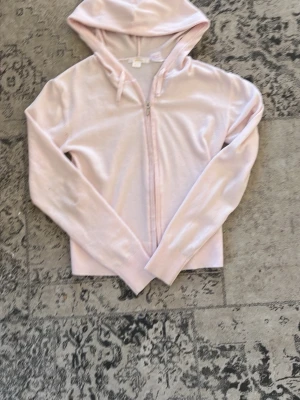 Ljusrosa hoodie med dragkedja - Snygg ljusrosa hoodie med dragkedja framtill och huva. Tillverkad i ett mjukt, tunt material som känns skönt mot huden. Perfekt för en avslappnad look! Finns två fläckar där framme som man säkert kan tvätta bort men jag har bara inte orkat, skriv för mer bilder eller om du har frågor! Pris är diskuterbart 🩷!