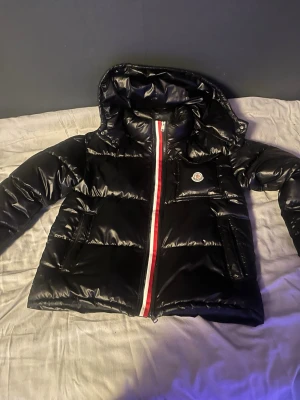 Svart Moncler Jacka - En svart Moncler Jacka väldigt varm för vintern men kan också användas för medelmåttig temperatur.Kan också bytas