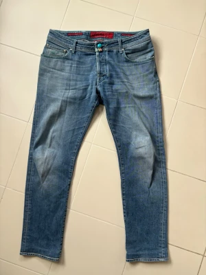 Jättefina Jacob Cohen jeans style 622 w35 - Blå stentvättade ursnygga populära och trendiga Jacob Cohen jeans av högsta kvalite i storlek w35 säljes. 46 breda i midjan och 101 cm total längd. Inga hål eller fläckar i utmärkt skick! Perfekta nu till sommaren och grym passform. Tveka inte vid minsta fråga!