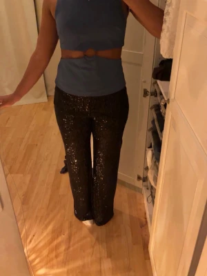 Svarta paljettbyxor med bootcut - Glittriga svarta byxor med paljetter och bootcut-modell. 