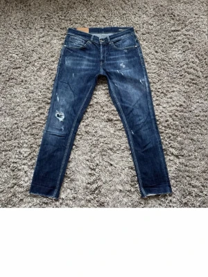 Mörkblå slitna skinny jeans - Säljer ett par mörkblå skinny jeans med slitningar och hål på ena benet. Jeansen har klassisk femficksmodell, låg midja och dragkedja. Perfekta för en avslappnad och trendig look. Skick 9,5/10. Storlek: W32 L 31 dem är uppsydda! Nypriset ligger på 3000 kr hör gärna av er om ni har funderingar!👍🏻