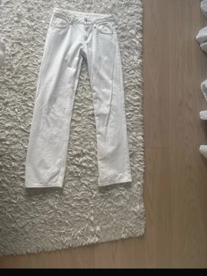 Vita raka jeans - Säljer ett par vita jeans med rak passform och low waist. Jeansen har bälteshällor och knappgylf. Perfekta för dig som vill ha en clean och stilren look till vardags. Materialet är denim i bomull.