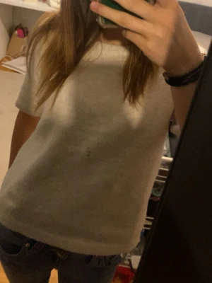 Vit kortärmad topp i mjukt material - En enkel och stickad beige topp med korta ärmar. Toppen är i mjukt material och använd ett fåtal gånger så är som ny!💕