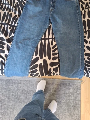 Blå raka jeans från Levi's - Säljer ett par klassiska blå Levi's jeans med rak passform och fem fickor. Jeansen har en tidlös tvätt och är tillverkade i slitstarkt denim. Perfekta för dig som gillar en enkel och clean look.