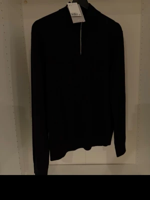 Svart merinoulltröja från H&M - Säljer en svart stickad tröja från H&M Premium Selection i mjuk merinoull. Tröjan har halv dragkedja framtill. Den är ny med prislapp på, cond 10/10.