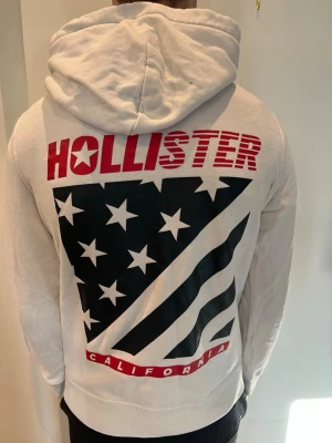 Vit hoodie från Hollister  - Snygg vit hoodie från Hollister i storlek S modellen är 181cm och väger 66kg 
