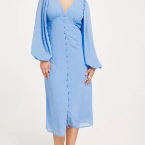 Blå långklänning från Vero Moda - Supersöt blå långklänning från Vero Moda med v-ringning, långa puffärmar och knappar framtill. Klänningen har ett diskret prickigt mönster i tyget och är tillverkad i ett lätt och luftigt material. Perfekt för sommarens alla tillfällen! (aldrig använt, prislappen är bara av… ord. Pris 499,95 kr)