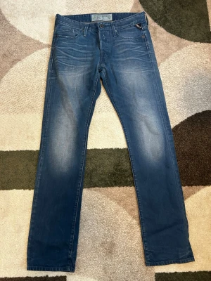 Replay jeans Blå - Snygga blå slim fit jeans från Replay med klassisk femficksdesign och diskreta slitningar framtill. Jeansen har en modern passform och är tillverkade i mjuk denim med lätt stretch för extra komfort. Perfekta för en avslappnad och trendig look. Priset är ej hugget i sten🙌