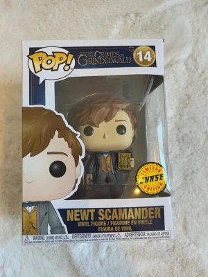 Funko Pop Newt Scamander #14 - Säljer en limited edition Funko Pop vinylfigur av Newt Scamander från Fantastic Beasts: The Crimes of Grindelwald. Figuren är nummer 14 och kommer i originalförpackning med fönster. Färgerna är brun, blå, grå och gul. Perfekt för samlare eller Harry Potter-fans.