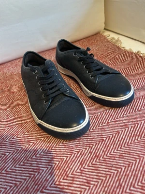 Lanvin Blåa - Snygga svarta sneakers med crocomönstrad yta och svarta skosnören. Skorna har en vit sula som ger en fräsch kontrast och en klassisk låg profil. Perfekta för dig som gillar stilrena och trendiga skor med lite edge.