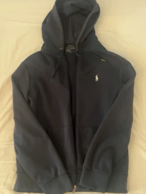 Ralph Lauren zip hoodie - Säljer nu denna Ralph Lauren zip hoodie i storleken S. Enda defekten är att ena metallsaken på snöret har gått av samt att de andra är lite böjt. NYPRIS: 1300 kr säljer nu för 700. Men kan gå ner lite i pris vid snabbköp. Så de är bara att höra av dig om du har frågor eller prisförslag!