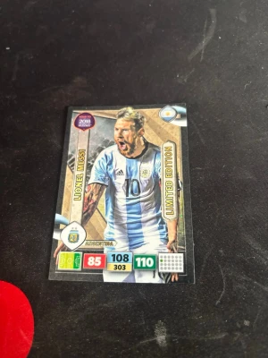 Panini Adrenalyn Messi Limited Edition - Samlarkort från Panini Adrenalyn XL Road to 2018 FIFA World Cup, Limited Edition med Lionel Messi i Argentinas landslagströja. Kortet har guldiga detaljer, spelarstatistik och är officiellt licensierat. Perfekt för dig som gillar fotboll och samlarkort.