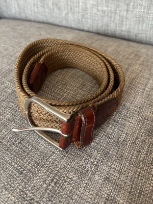 Beige flätat bälte från saddler  - Snyggt beige flätat bälte med läder vid spännet och änden.  Legat i garderoben lite för länge nu. Skriv vid minsta fundering.