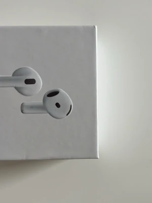 Apple AirPods 3 med laddningsetui - Säljer ett par vita Apple AirPods 3 med trådlöst laddningsetui. Hörlurarna har en stilren och modern design i blank plast och sitter bekvämt i öronen. Perfekta för musik, samtal och poddar med grymt ljud och enkel anslutning till iPhone.