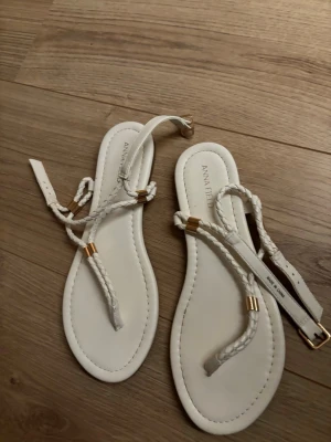 Vita flätade sandaler från Anna Field - Snygga vita sandaler från Anna Field med flätade remmar och guldfärgade detaljer. Sandalerna har en smal sula och justerbart spänne vid ankeln. Använda en gång!💞i storlek 38