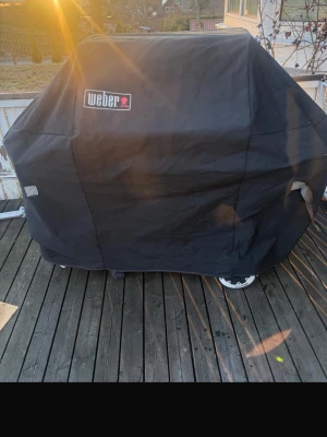 Svart grill med skydd Weber - Säljer en stor grill från Weber med svart skydd. Grillen har detaljer i rostfritt stål och robust handtag. Perfekt för dig som gillar att grilla ute på altanen. Klassisk design och tydlig Weber-logga på både skydd och grill, den kommer ej med gasol
