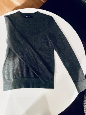 Mörkgrå merinoullströja från Riley - Stilren mörkgrå tröja från Riley i mjuk merinoull. Storlek S / xs